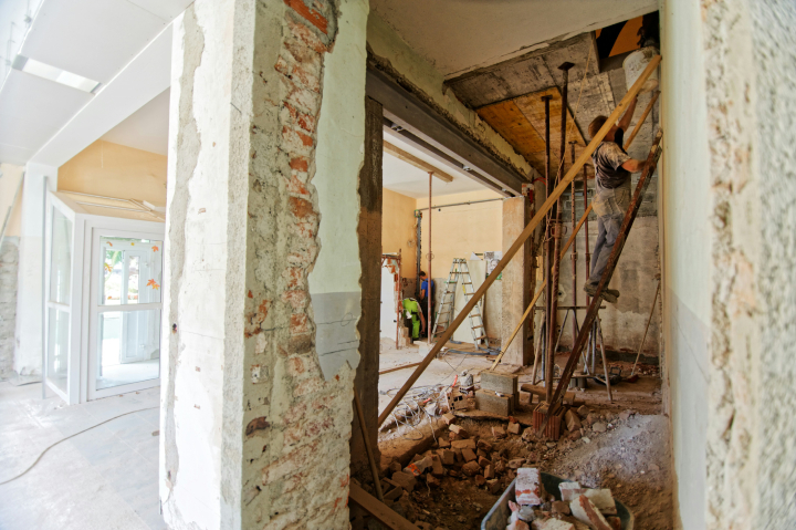 Um homem numa escada dentro de uma casa em construção
